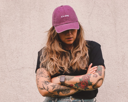 image: girl with arm tattoos wearing raspberry cap and essential black t-shirt made with organic cotton in Portugal. pt. mulher com tatuagens com um boné raspberry e a t-shirt orgânica essential em preto. 