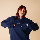 Woman wearing navy IT’S OKAY organic cotton crewneck, showing relaxed oversized fit.