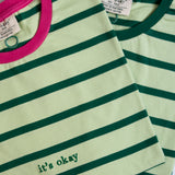 Green and white striped shirt with 'it's okay' text, close-up view.