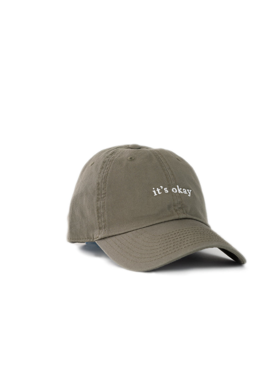 it's okay organic cap green| made with organic cotton, embroidered. This is a studio photography of the cap.