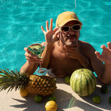 Sunflower cap, yellow cap made with 100% cotton, embroidered. it's okay to be exactly who you are. From Portugal with love. Boné de pala amarelo de algodão bordado em Portugal. Image: Mustache man in a pool with a martini drink and fruit wearing the sunflower cap. 